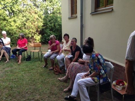 Gemeindemitglieder im Garten nach dem Gottesdienst